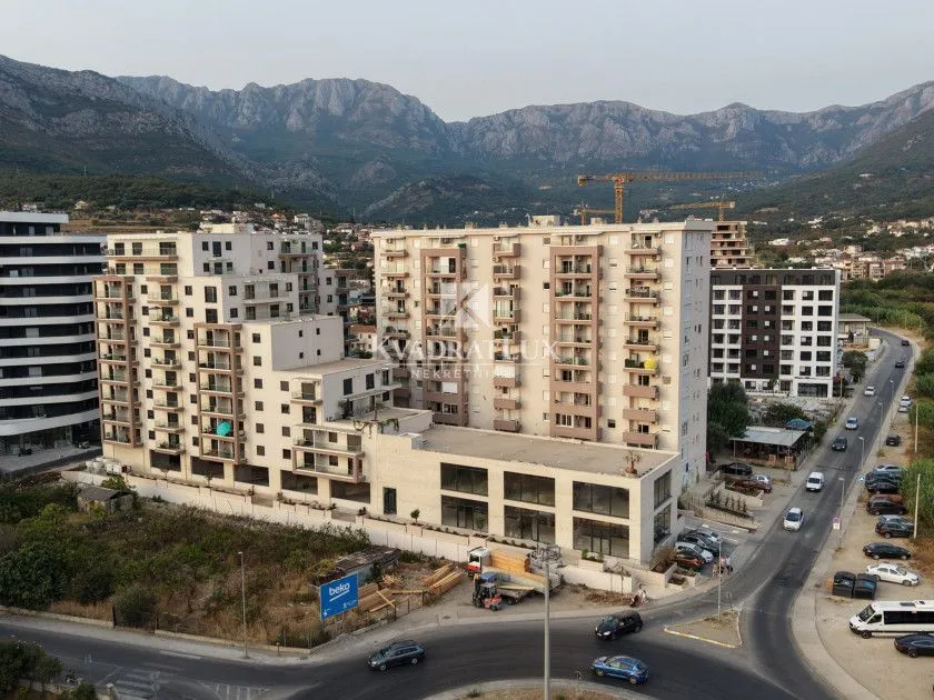 Pogled iz vazduha na stambene zgrade sa planinama u pozadini.