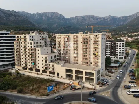 Pogled iz vazduha na stambene zgrade sa planinama u pozadini. - image 8