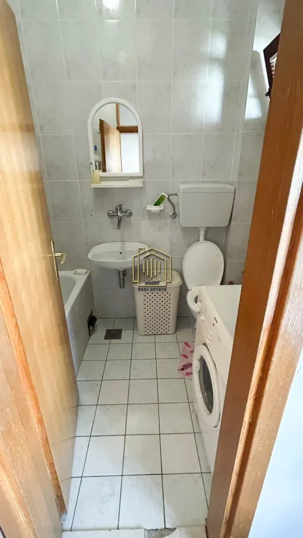 Manje kupatilo opremljeno sanitarijama i veš mašinom.