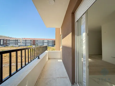 Nenamješten balkon sa metalnom ogradom i pogledom na okolne zgrade. - image 5