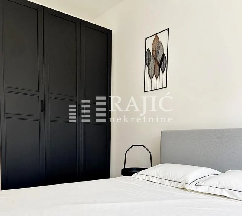 Modern bedroom with a double bed and a large black wardrobe.