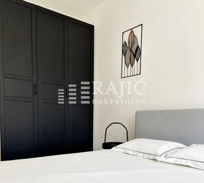 Modern bedroom with a double bed and a large black wardrobe. - image 10