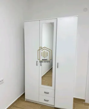 Bijeli garderober sa ogledalom i dvije ladice u sobi. - image 8