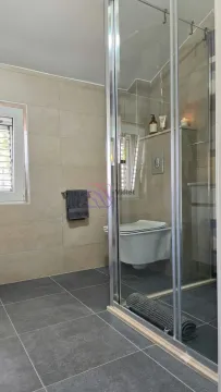 Modernly equipped bathroom with a shower cabin and a wall-mounted toilet. - image 6