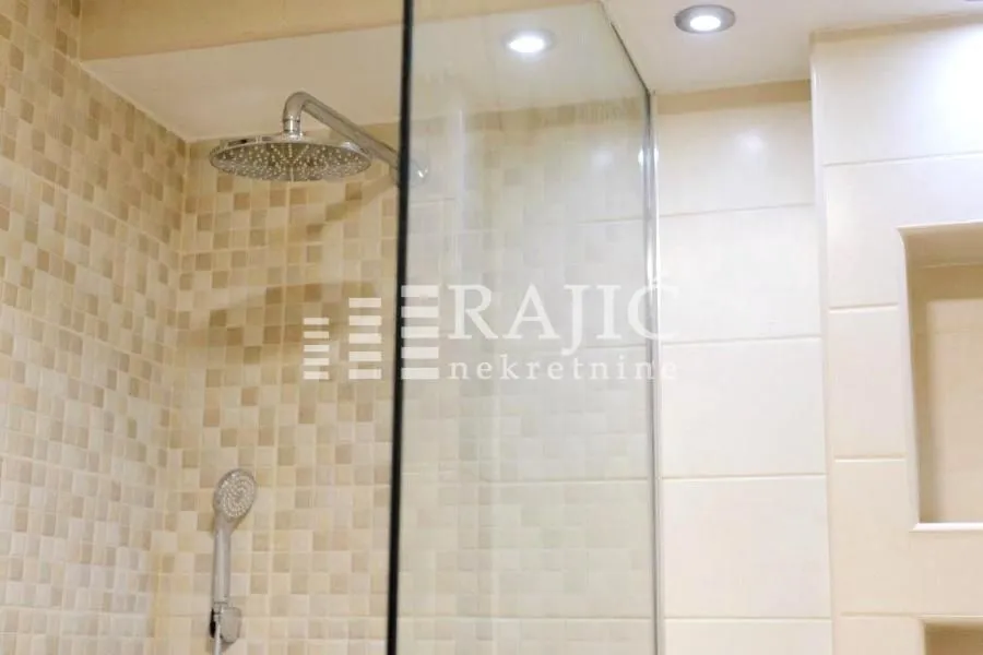 Modern bathroom with a walk-in shower and mosaic tiles.