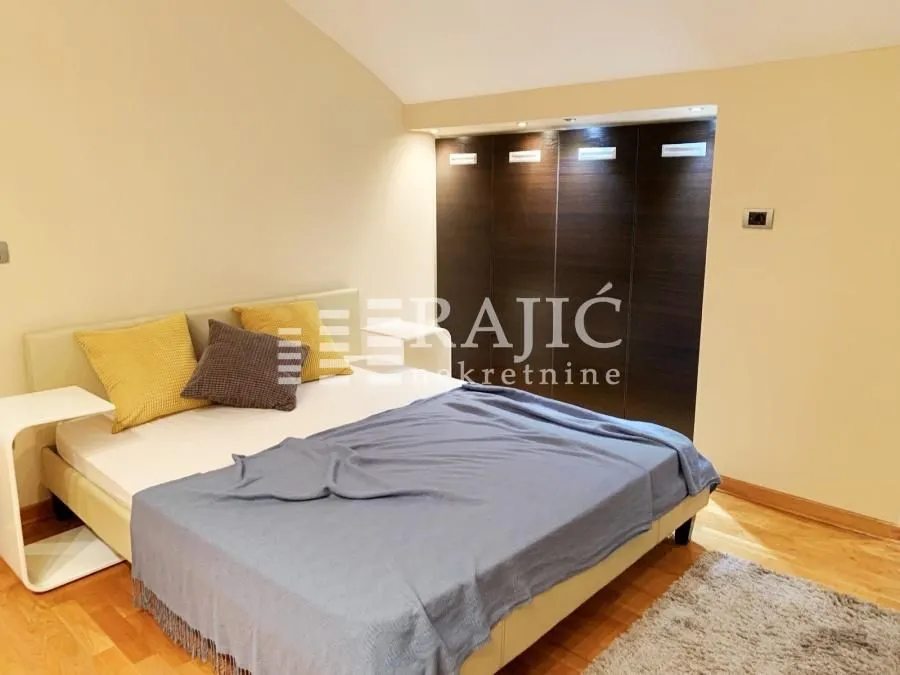 Furnished bedroom with a double bed and built-in wardrobe.