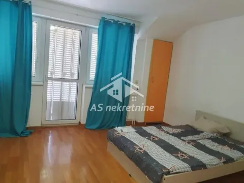 Bedroom with a double bed, wooden flooring, and balcony doors with turquoise curtains. - image 30