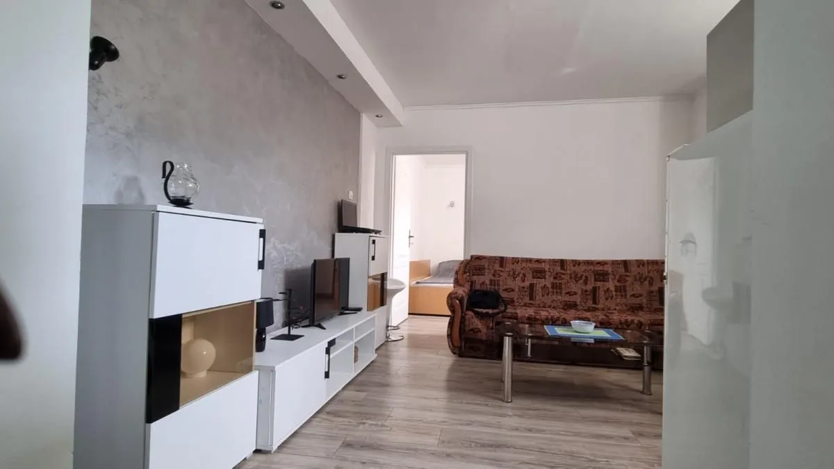 Dnevna soba sa garniturom za sedenje i TV komodom.