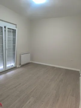 Empty room with laminate flooring and balcony doors. - image 9