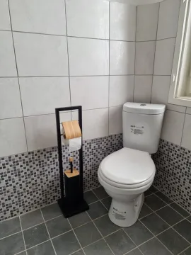 View of the bathroom with a toilet and toilet paper holder. - image 3
