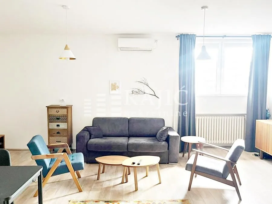 Living room with sofa, armchairs and a dining table.