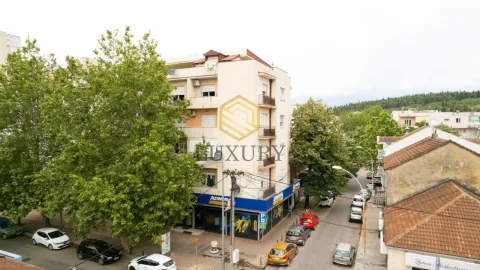 Aerial view of an apartment building and a street with parked cars. - image 4