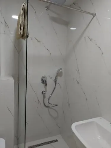 Modern shower cabin with marble-style tiles.