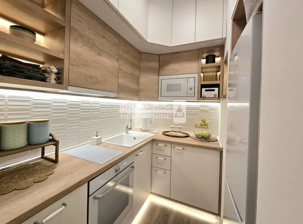 Modern kitchen with wooden elements and built-in appliances.