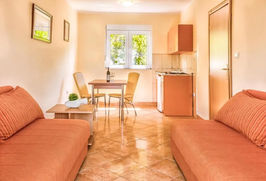 Living room with sofa, dining area, and kitchenette.