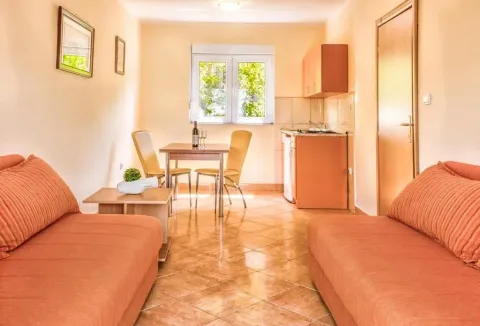 Living room with sofa, dining area, and kitchenette. - image 10