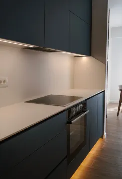 Modern kitchen with dark cabinets, built-in oven, and countertop. - image 2