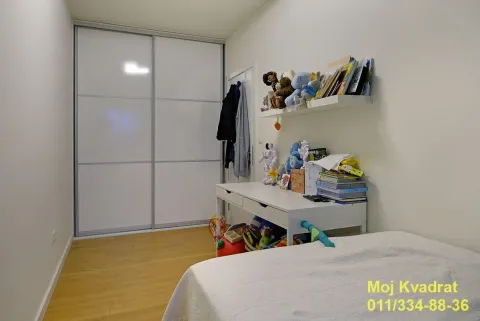 Children's bedroom with a large built-in wardrobe, desk, and bed. - image 10