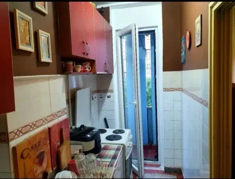 Mala kuhinja sa crvenim elementima i izlazom na balkon. - image 5