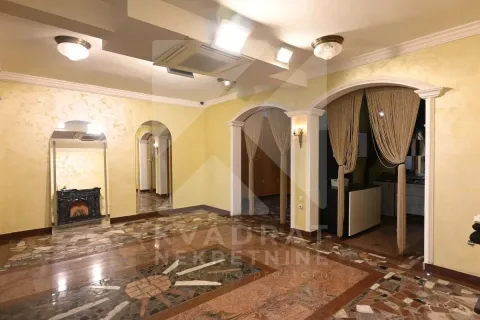Spacious living room with decorative tile flooring and arched doorways. - image 6