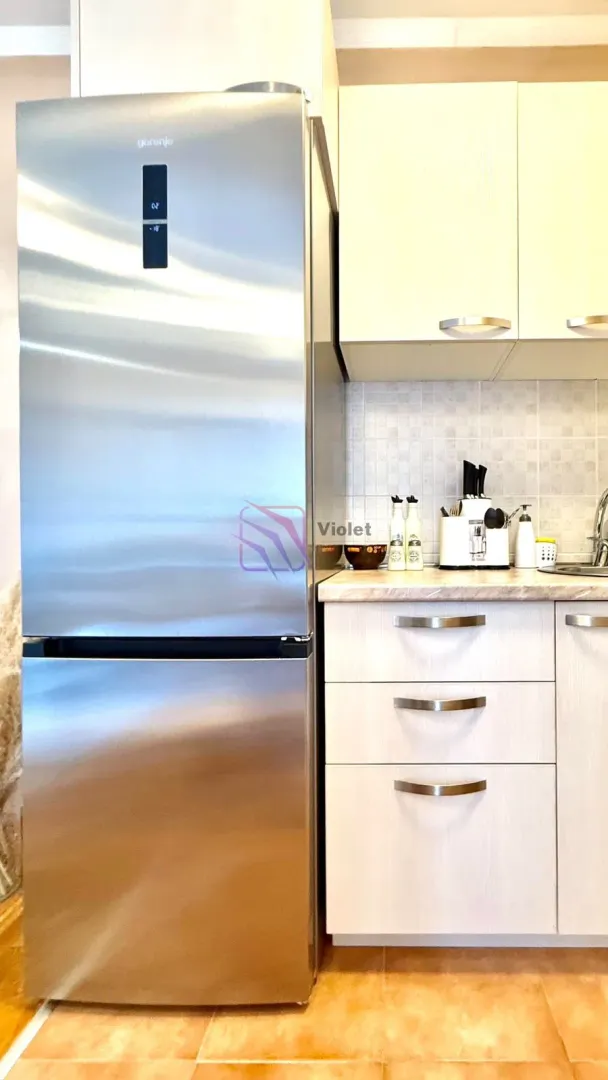 Part of the kitchen with a refrigerator, base cabinets, and upper cabinets.