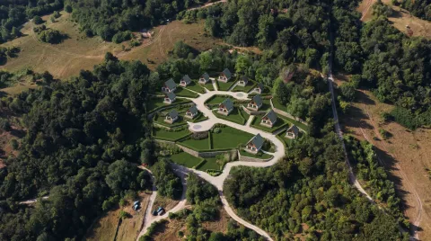 Pogled iz vazduha na kompleks kuća okružen šumom. - image 4