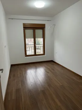 Prazna soba sa svijetlim zidovima, tamnim parketom i prozorom. - image 5