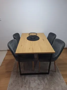 Wooden dining table with four upholstered grey chairs. - image 3