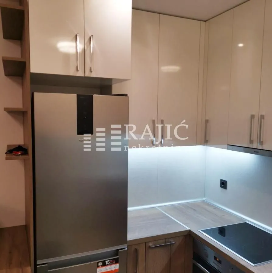 Modern kitchen with light cabinetry and built-in appliances.