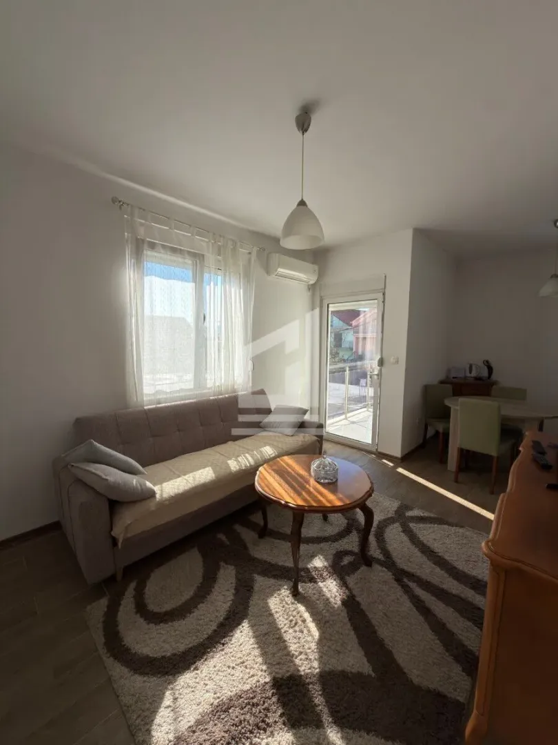 Living room with sofa, coffee table and access to the terrace.