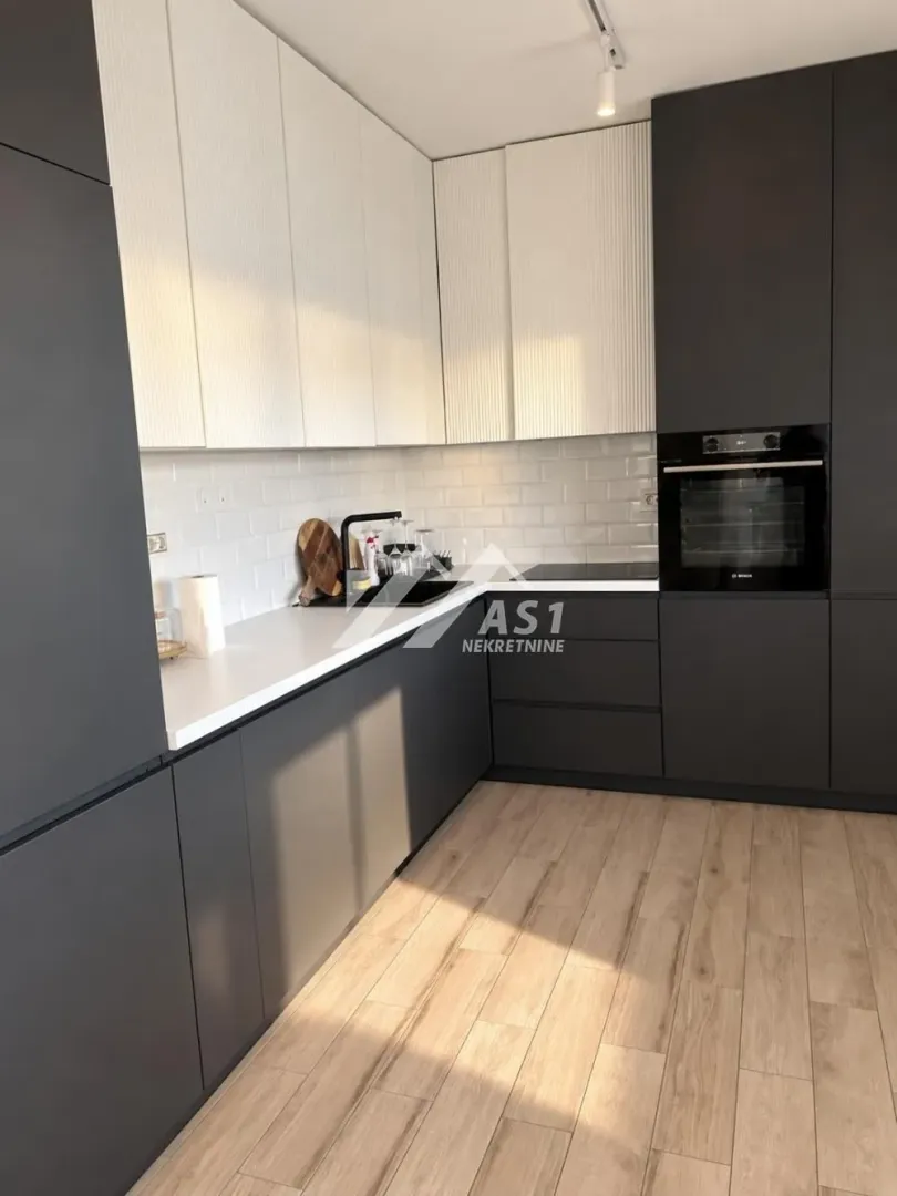 Modern kitchen with dark base cabinets and white upper cabinets.