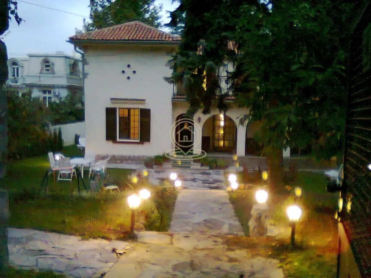 Exterior view of the house with an illuminated pathway and yard at night.
