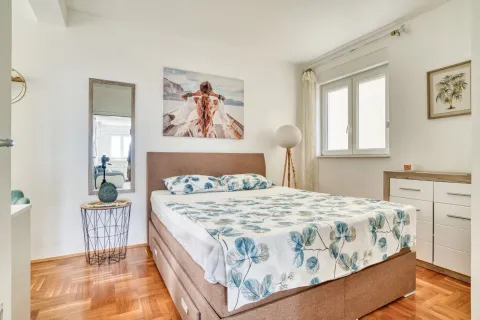 Bedroom with a double bed, chest of drawers, mirror and window. - image 11