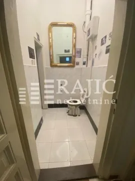 View of the bathroom with toilet, mirror, and tiling. - image 11