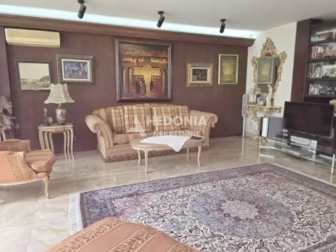 Prostrani dnevni boravak sa garniturom, drvenim zidnim oblogama i klasičnim nameštajem. - image 5