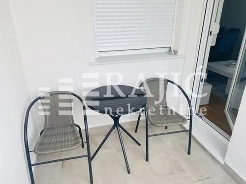 Small balcony with a table and two chairs.