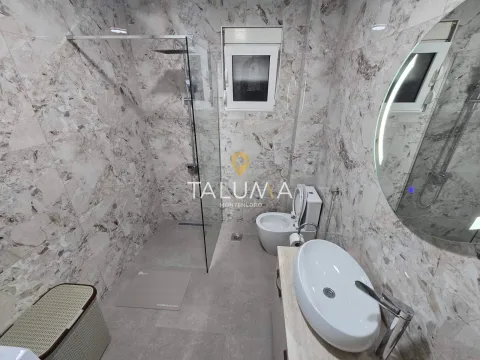 Modern bathroom with a walk-in shower, washbasin, and toilet, finished with marble tiles. - image 9