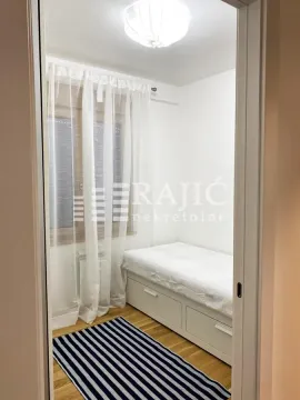 Small bedroom with a bed and a window covered with white curtains. - image 3