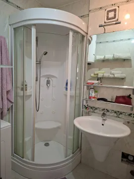 Kupatilo opremljeno tuš kabinom i umivaonikom sa ogledalom. - image 16
