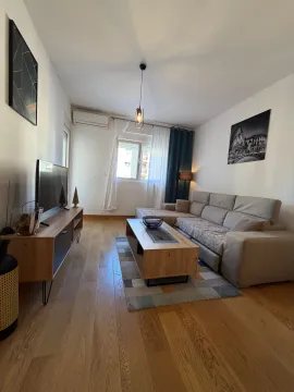 Living room with sofa, television and wooden coffee table. - image 2