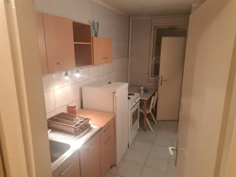 Smaller kitchen with wooden units, a refrigerator, and a stove. - image 2