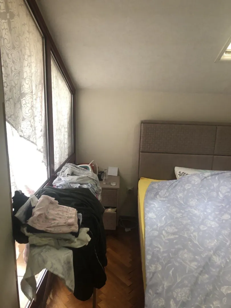 Spavaća soba sa krevetom pored prozora.