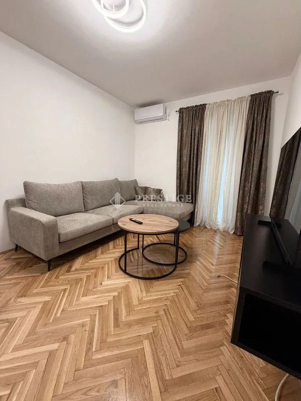 Living room with a sofa and parquet flooring.
