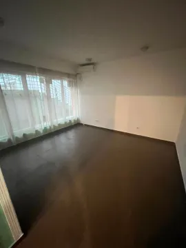 Empty room with dark flooring and a large window with curtains. - image 9