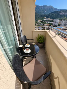 Furnished balcony space with a small table, chairs, and a nice view of the mountains. - image 6