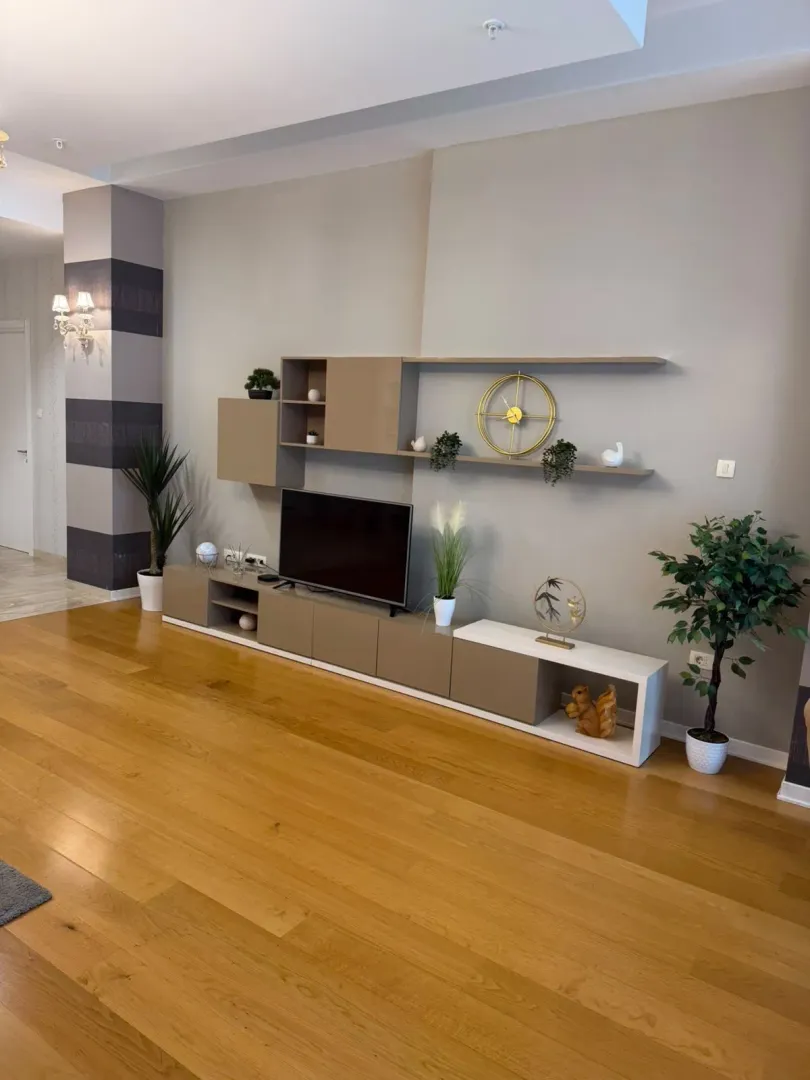 View of the TV unit and decorative shelves in the living room.