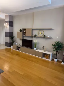 View of the TV unit and decorative shelves in the living room. - image 4