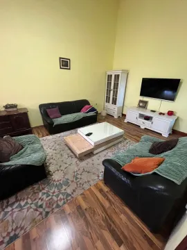Dnevna soba sa garniturom, stočićem i televizorom na zidu. - image 8