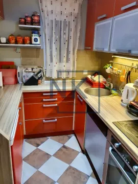 Smaller U-shaped kitchen with orange cabinets and patterned floor tiles. - image 5