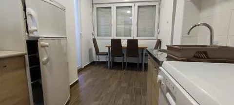 Kitchen and dining area with a table and refrigerator. - image 13